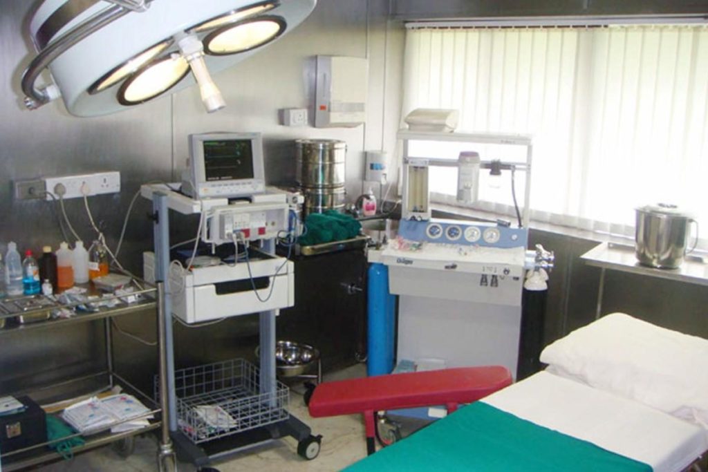 An operating room equipped with medical machinery, surgical instruments, and a patient bed, highlighting a sterile environment for laser surgery.